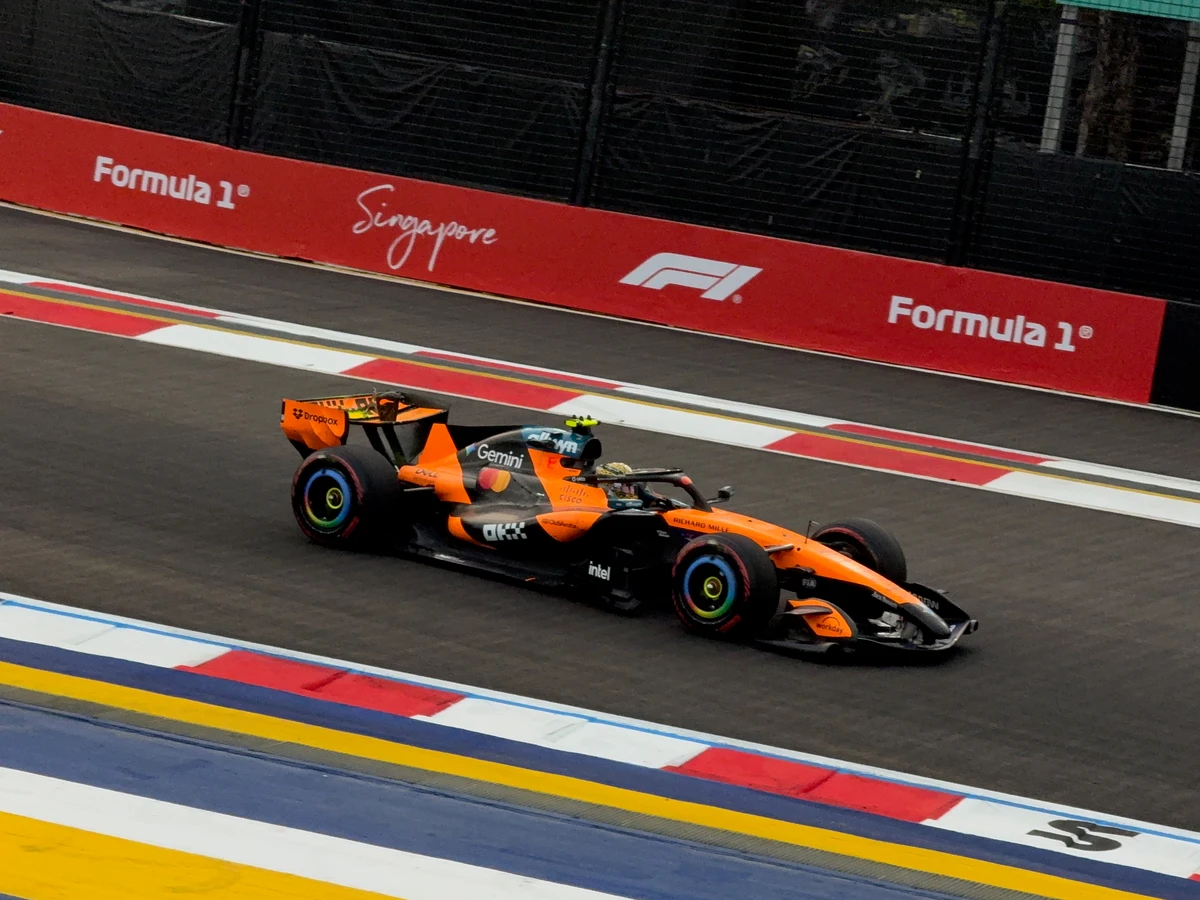 An orange race car in a sharp action shot at the Singapore circuit.