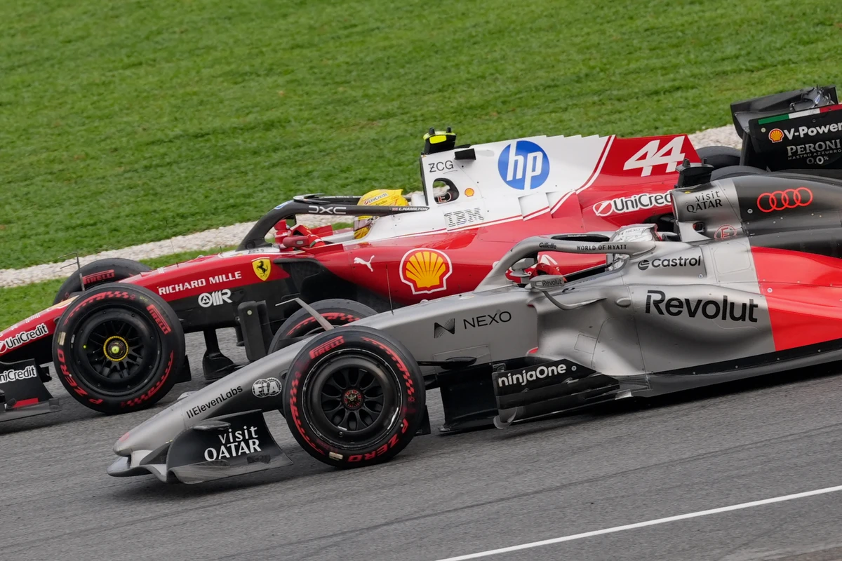 Close view of a red Ferrari alongside a silver and red Audi at Sepang Circuit