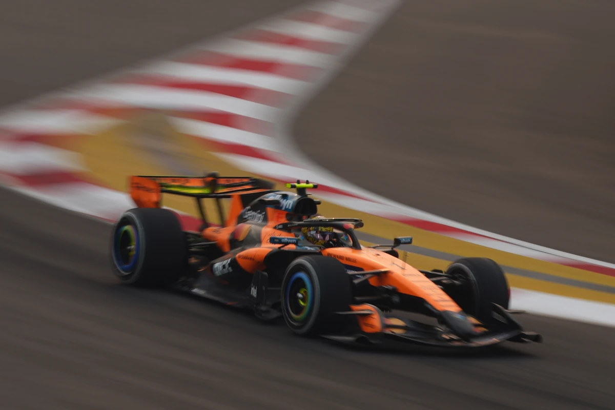 Orange McLaren panning past blurred red, white, and yellow markings at the Singapore GP